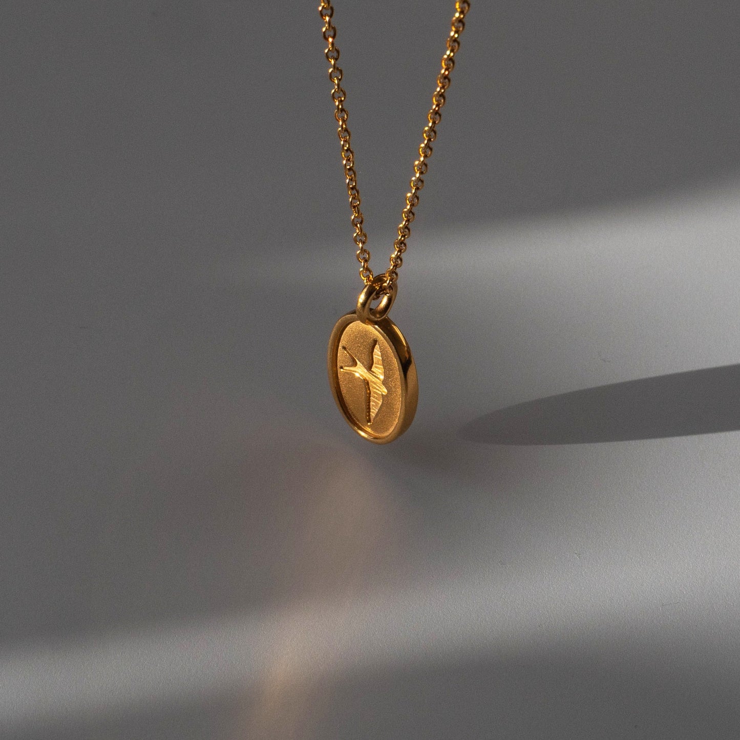The Libertad necklace, an exquisite pendant representing the essence of freedom, elegantly showcases a delicately crafted bird symbol. The intricately designed pendant serves as a powerful emblem of liberty and independence.